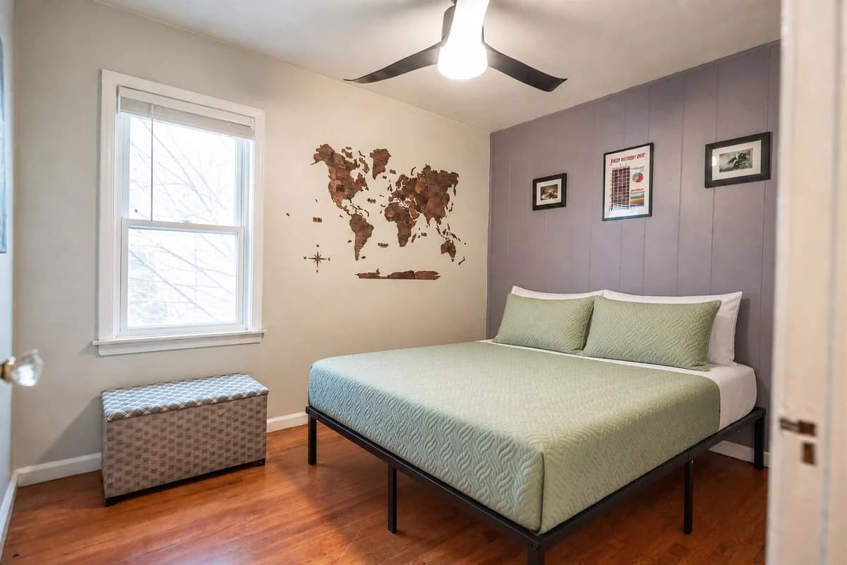 Bedroom with world-map wall decor and green bedding